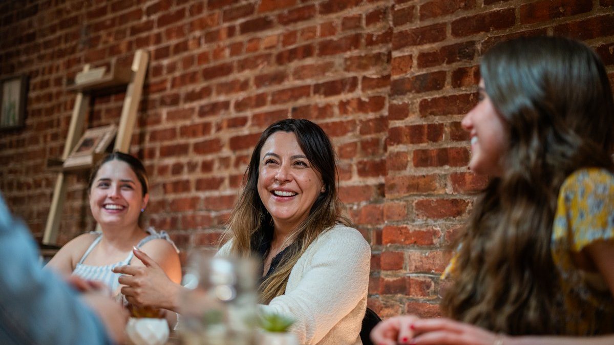 Women in a dinner group in conversation around a table