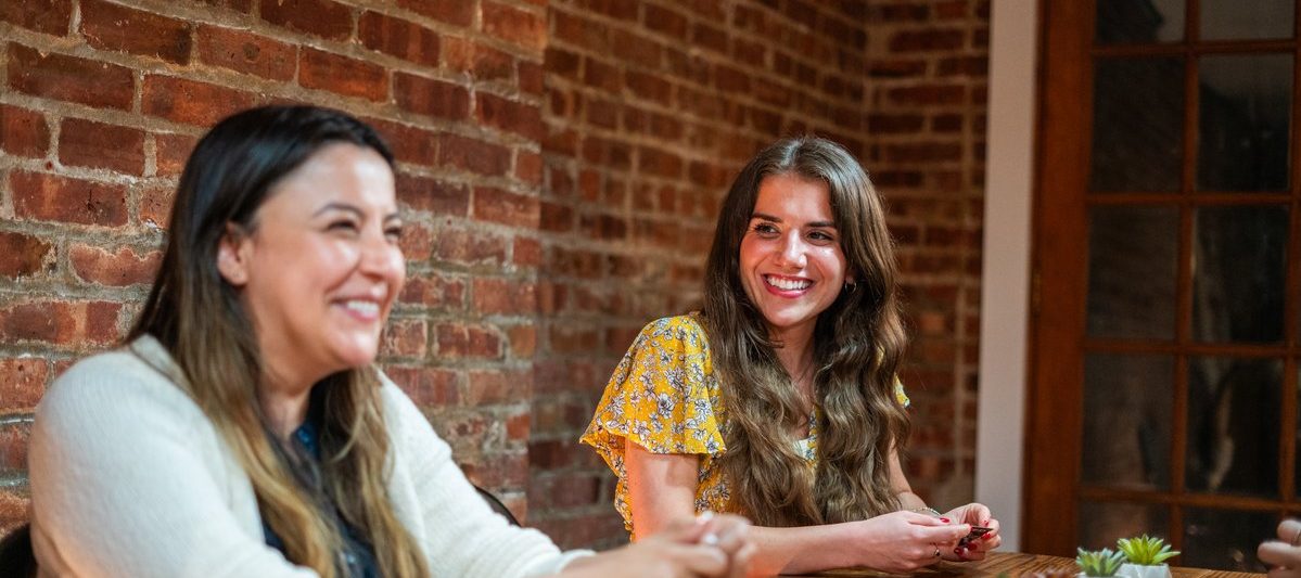 Two dinner group members talking and laughing at a table